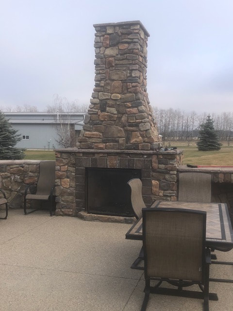 custom do-all stucco & stone built exterior stone fireplace